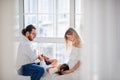 Little girl laughs lies on the lap of pregnant mother the father tickles daughter. Happy family Royalty Free Stock Photo