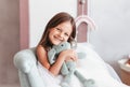 Little girl laughs and plays with a soft toy in the children`s room Royalty Free Stock Photo