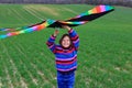 Little girl launches a kite in a field in spring. Royalty Free Stock Photo