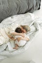 The little girl lay down on her mother and wants to sleep. Mom tenderly hugs her daughter