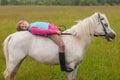 The little girl lay on her back white horse Royalty Free Stock Photo