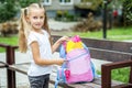 A little girl is laying books in her school backpack. The concept of school, study, education, friendship, childhood. Royalty Free Stock Photo
