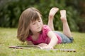 Little girl laying in grass reading