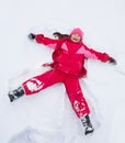 Little girl laying in star shape in snow Royalty Free Stock Photo