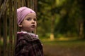 A little girl leaning against a gate in the park. Autumn colors Royalty Free Stock Photo