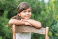 Little girl is leaning on an old wooden chair Royalty Free Stock Photo