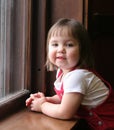 Little girl leaning on window sill Royalty Free Stock Photo