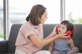 Little girl with learning disabilities or the group of dow syndrome is listening music from headphone with mother teaching and Royalty Free Stock Photo