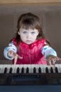 Little girl learning to play piano. Concept of music study and creative hobby