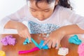 Little girl is learning to use colorful play dough