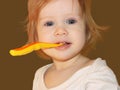 A little girl learns to brush her first milk teeth.