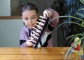 A little girl learns to play chess and demonstrates a magnetic chessboard with pleasure. Cultural leisure for children