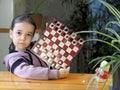 A little girl learns to play chess and demonstrates a magnetic chessboard with pleasure. Cultural leisure for children