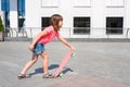 The little girl, learns to ride a board. The child riding a skateboard. Active sport in the open air for children Royalty Free Stock Photo