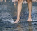 Little girl leg playing with fountain water jets at the street Royalty Free Stock Photo