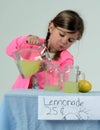 Little girl at lemonade stand pouring lemonade Royalty Free Stock Photo