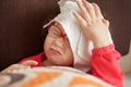 a little girl lies on a bed and pretends to be sick