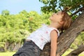 Little girl lies on caudex of tree