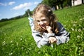 Little girl lies on a green field
