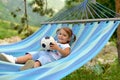 A little girl lies in a hammock with a ball and smiles. Royalty Free Stock Photo