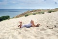 a little girl lies on the sand in the dunes on the Curonian spit.Lithuania Royalty Free Stock Photo