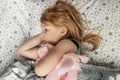 A little girl lies under a blanket with a toy dog getting ready for bed Royalty Free Stock Photo