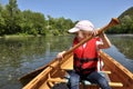 Little girl in a life jacket in a canoe