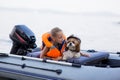 Little girl in a life jacket with her dog in a boat on the lake. Safety. summer rest Royalty Free Stock Photo