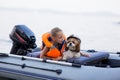 Little girl in a life jacket with her dog in a boat on the lake. Safety. summer rest