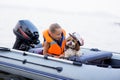 Little girl in a life jacket with her dog in a boat on the lake. Safety. summer rest Royalty Free Stock Photo