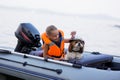 Little girl in a life jacket with her dog in a boat on the lake. Safety. summer rest Royalty Free Stock Photo