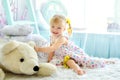 Little girl in light bedroom with big white teddy bear Royalty Free Stock Photo