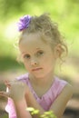 Little girl in a lilac dress with a flower in her hair