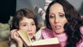 Little girl listening attentively to fairy tales, reading with mother, close up