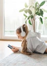 Little girl listening music lying on the floor Royalty Free Stock Photo