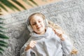 Little girl listening music lying on the floor Royalty Free Stock Photo