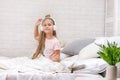 Little girl listening to the music with the headphones on bed. Royalty Free Stock Photo