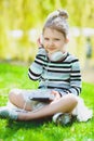 Little girl listening to music on headphones in a spring park outdoor Royalty Free Stock Photo