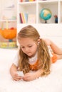 Little girl listening to music laying on the floor Royalty Free Stock Photo