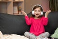 Little Girl Listens To Music On Wireless Headphones. Funny Little Girl Dancing, Singing And Moving To Rhythm. Kid Royalty Free Stock Photo