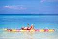 Little girl with lollipop have fun on surfboard in Royalty Free Stock Photo