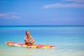 Little girl with lollipop have fun on surfboard in Royalty Free Stock Photo