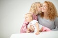 Little girl with lonf curly hare loves her mother and little sister Royalty Free Stock Photo