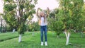 Little girl with long hair in jeans jumps. little girl in a green lawn garden. children`s happiness. Slow motion