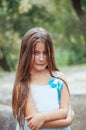 Little girl with long hair portrait, emotionally crying and upset, natural lighting outside