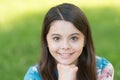 Little girl with long hair relaxing in park sunny day green grass background, adorable smile concept Royalty Free Stock Photo