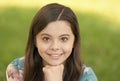 Little girl with long hair relaxing in park sunny day green grass background, adorable smile concept Royalty Free Stock Photo