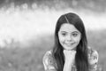 Little girl with long hair relaxing in park sunny day green grass background, optimism and positivity concept Royalty Free Stock Photo