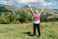 Little girl look into the distance on a grassy hill. portrait of a girl against the panorama of the Alps. happy children Royalty Free Stock Photo