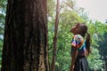 The little girl looked up lovingly at the old big tree in the forest. Green environmentally friendly lifestyle. Love and protect